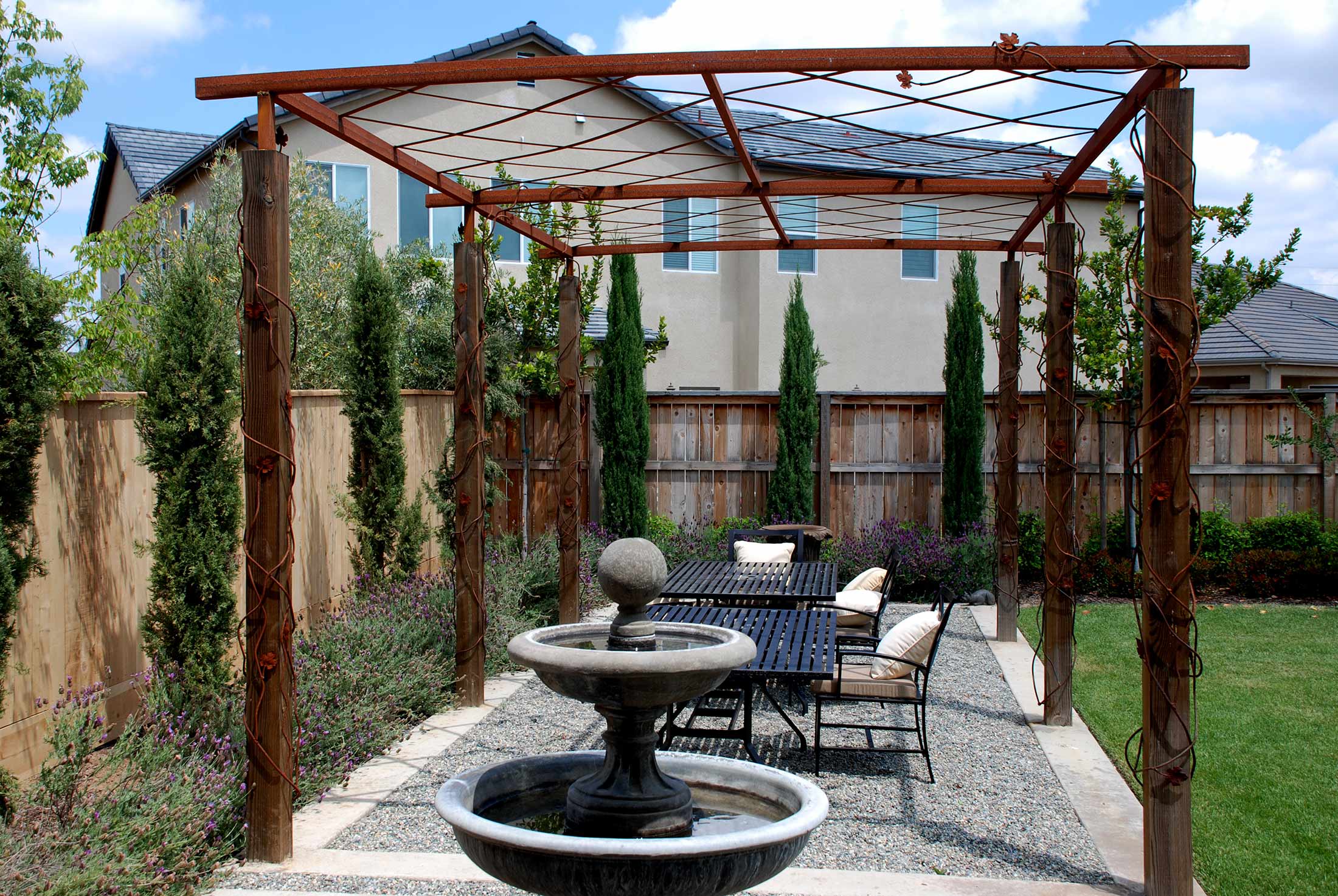 outdoor dining area under pergola lattice with water feature fountain