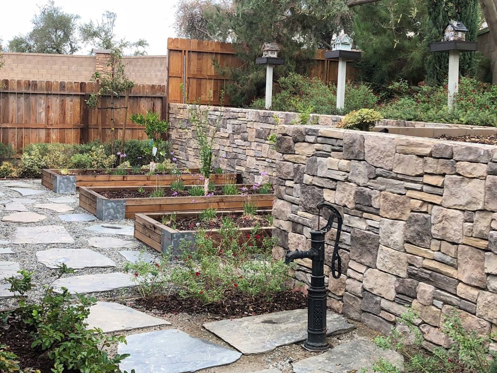 custom residential backyard stone retaining wall with planter boxes