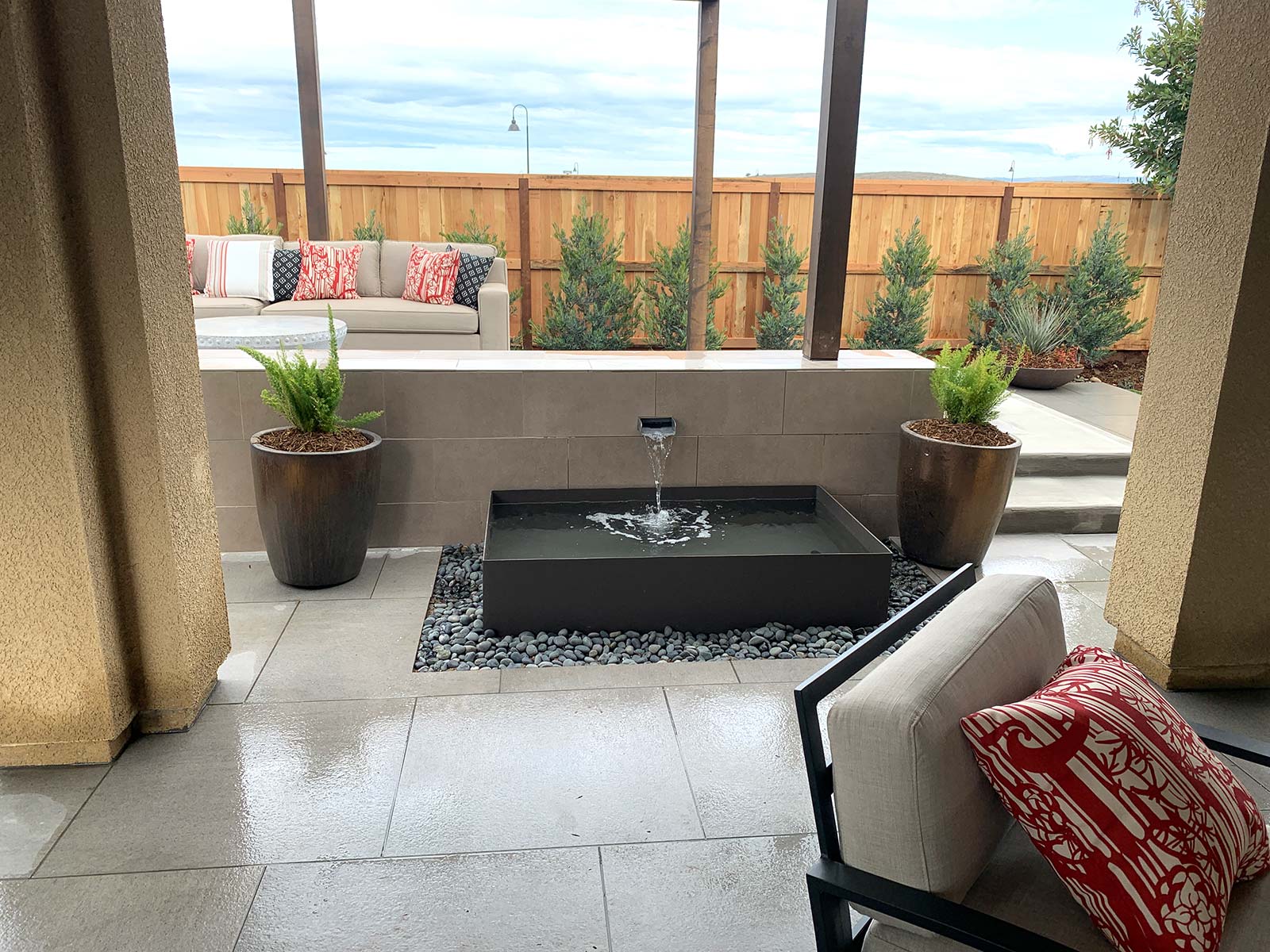 residential backyard covered patio sitting area with water feature